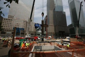 A crane lowers the "WTC Cross" into the National September 11 Memorial and Museum.  Image credit:  National September 11 Memorial & Museum.